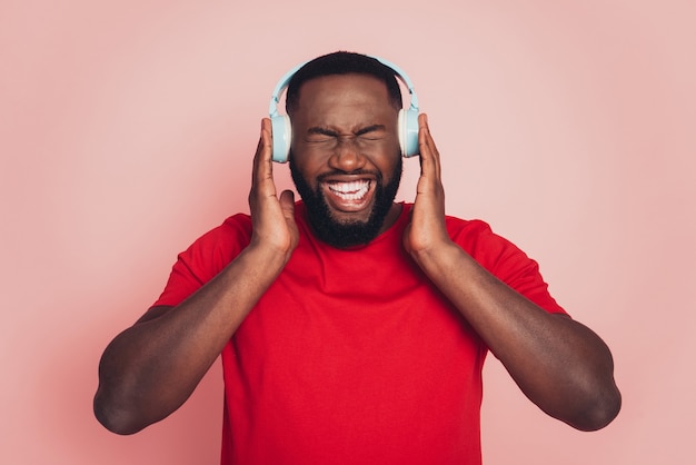 Premium Photo | Young african american man listen loud music headset over  pink background